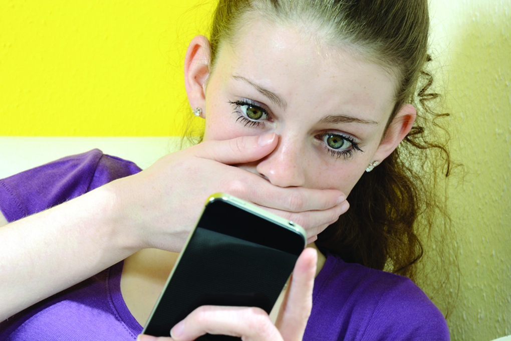 Schülerin erhält schlechte Nachricht auf Smartphone